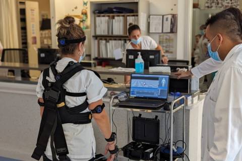 Una sanitaria probando el exoesqueleto junto a investigadores de la UPCT.